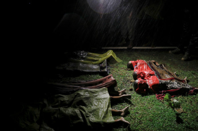 Bodies of children and other Rohingya refugees are covered after their boat with passengers fleeing from Myanmar capsized off the Inani beach near Cox's Bazar